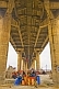 Image of Colorful Kumbh Mela festival tents under concrete  pillars of the Lal Bahadur Shastri Bridge.