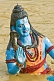 Statue Of Blue-Skinned God Shiva Beckons From The Muddy Waters Of The Ganges