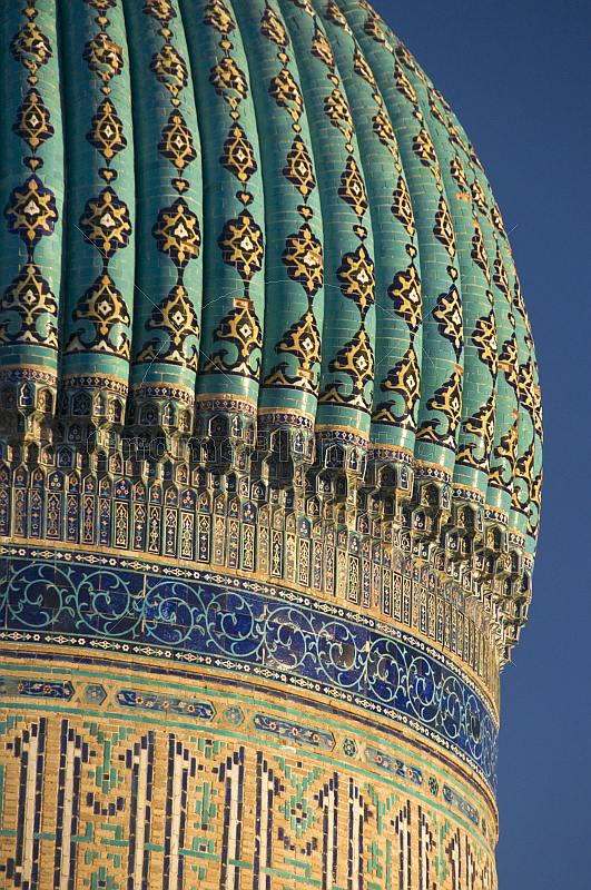 Blue tiled dome of the Yasaui Mausoleum in the evening sunlight.