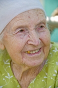 Old Kazakh lady with gold tooth and head-scarf.