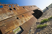 A traveller examines the remains of a ship abandoned in the dried up bed of the Aral Sea, near Aralsk.