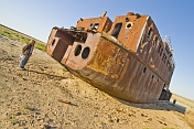 Travellers examine the remains of a ship abandoned in the dried up bed of the Aral Sea, near Aralsk.