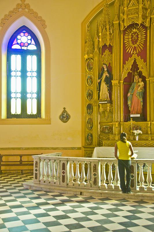 Young woman reads the Bible in the Cafayate Cathedral.