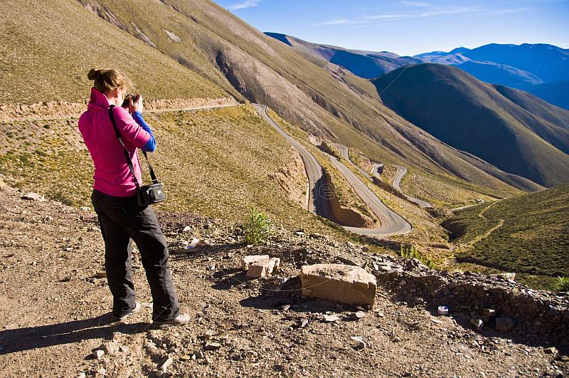 Woman photographs the Cuesta de Lipan - a section of steep zigzag road on the National Route 52 highway.