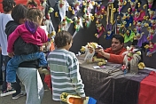 A puppet-maker shows his wares to visiting children.