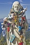 Statue of Christ with good-luck charms and wishes hung for blessings.