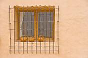 Barred window with ceramic teapots in Purmamarca.