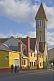 Image of Church and sunlit colorful houses.