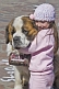 Image of Small girl hugs huge Saint Bernard dog.