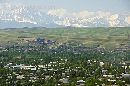 View over the city rooftops to the snow-capped Pamir Alay Mountains.