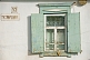 Image of Whitewashed cottage wall and green window frame.