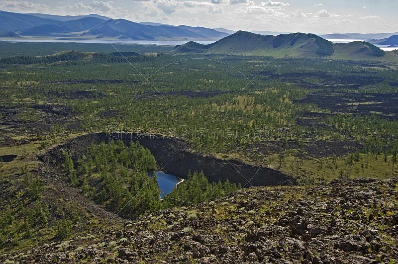 A view from the extinct Khorgo Uul volcano caldera over the rich volcanic lava fields and a crater lake.