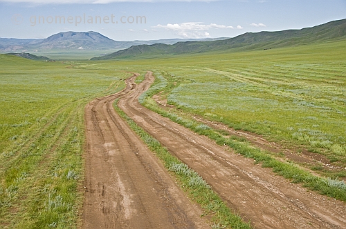 Un-surfaced dirt roads cross the Mongolian grassland.