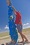Tying a Blue Khadag scarf to an Ovoo, a Mongolian Shamanistic cairn for travellers.