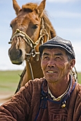 Mongolian horseman in traditional Mongol costume, with horse.