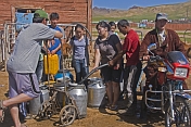 Mongolian villagers filling water cans from a communal hose.
