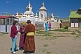 An elderly Mongolian couple in traditional dress talk after the service at the Gandan Muntsaglan Khiid monastery.