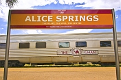 Ghan carriages under Alice Springs station signboard