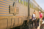 Indian Pacific passengers walk beside train carriages at Cook railroad station.