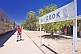 Image of Passengers from Indian Pacific train walk past Cook railway station signboard.