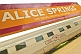 Image of Great Southern Rail station signboard and Ghan train carriages at Alice Springs.