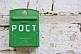 Image of Green post-box on a whitewashed wall.