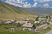 Small Russian village of log houses nestles between the Altai Mountains.