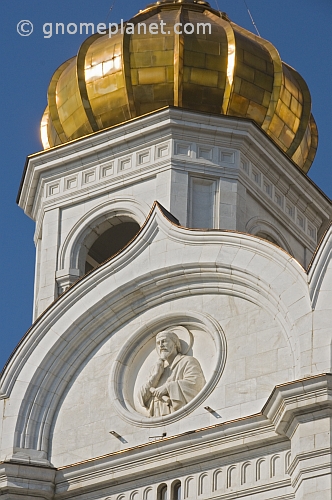 Detail of stone carving and gold dome on the Cathedral of Christ the Saviour which stands next to the Moscow River.
