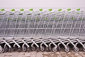 A line of supermarket shopping trolleys, outside a modern Russian supermarket.