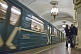 Image of Speeding underground train, and couple talking on the Metro platform.