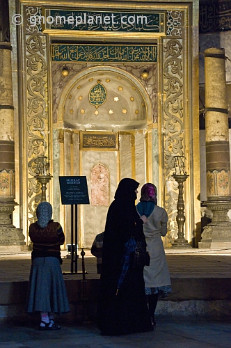 Three female pilgrims view the mihrab of the Aya Sofya in Sultanahmet.