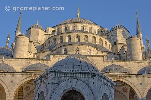 Domes of the Ahmet Camii Blue Mosque lit by evening sunshine.