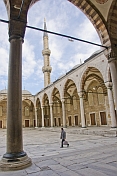 Man walks across courtyard of Sultan Ahmet\\\\'s blue mosque in Sultanahmet.