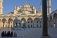 Worshippers wait in the courtyard of the Ahmet Camii Blue Mosque lit by evening sunshine.