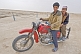 Image of Two Turkman desert dwellers on a motorbike at the Darvaza Water Crater.