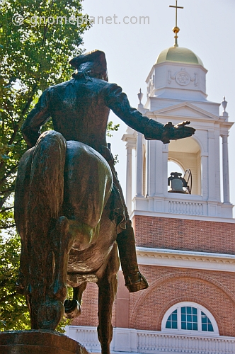 Bronze statue of Paul Revere in front of city church.