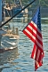 Image of U.S.A. flag 'Stars and Stripes' hangs from boom on sailing ship in harbour.