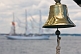 Image of Ships bell of the barque 'Picton Castle' with tallship 'Sagres' in background.