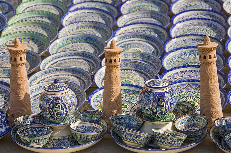 Ceramic minatures of the Kalon Minaret contrast the blues and greens of pottery bowls and plates.