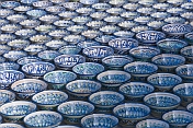 Trader\\\\'s display of blue and white pottery bowls tempts the traveller in Bukhara\\\\'s Central Asian Bazaar.