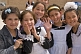 Image of Smiling school Children in traditional black and white uniforms greet visitors from abroad.