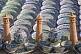 Image of Ceramic minatures of the Kalon Minaret contrast the blues and greens of pottery bowls and plates.