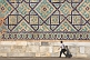 Small boy walks in front of the tiled mosiacs on the Sher-Dor Madrasah.
