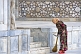 Image of A lady sweeper cleans the marble floor in front of the Ulugbek Medressa.