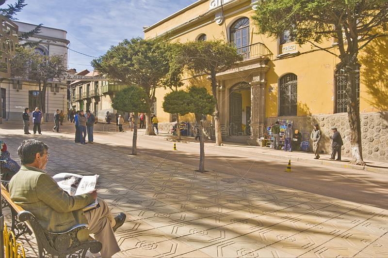 Man reads newspaper in the Plaza 10 de Noviembre.