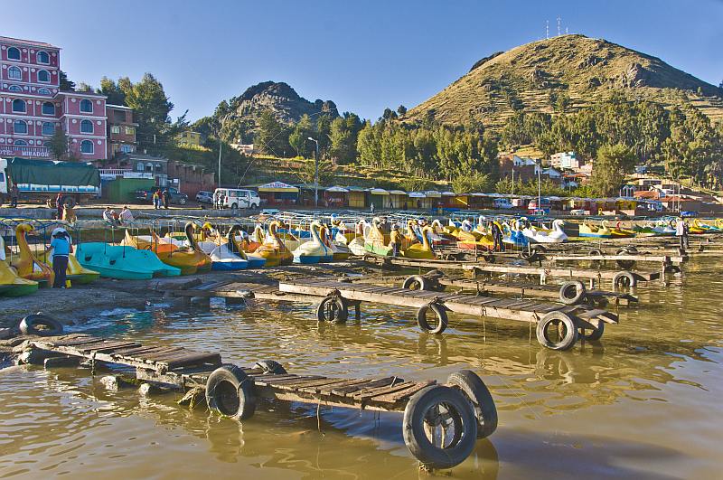 Jettys and pedalos pulled up on the shore of Lake Titicaca.