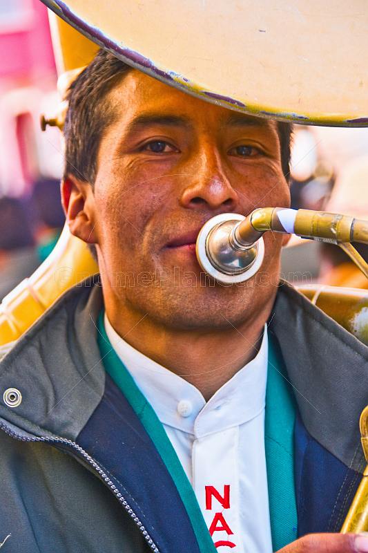 Sousaphone player in a brass band marching through the streets in a traditional town festival.
