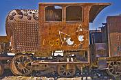 Rusting steam locomotive with graffiti in the cemetery of steam engines.