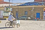Ice cream seller cycles along a street.