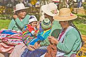 Bolivian women in hats with colorful babies.